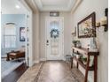 Bright foyer featuring decorative glass door, tile flooring, and wood console table at 4903 Eastlake Vista Dr, St Cloud, FL 34771
