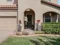 A charming front entrance with decorative plants, a manicured lawn, and a covered doorway at 4903 Eastlake Vista Dr, St Cloud, FL 34771