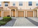 Attractive townhome featuring a two-car garage with manicured landscaping at 5076 Tideview Cir # 90, Orlando, FL 32819