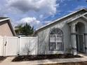 Well-maintained home exterior with white fence, tidy landscaping, and charming architectural details at 513 Seasons Ct, Winter Springs, FL 32708
