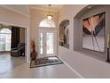 Inviting foyer with decorative art niches, stylish lighting, tiled flooring, and decorative glass entry door at 8011 Saint James Way, Mount Dora, FL 32757