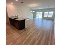 Open-concept living and dining area with wood-look flooring and natural light at 9436 Westside Hills Dr, Davenport, FL 33896