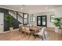 Bright dining area with wood table, modern chairs, wood floors, and stylish black accent wall at 9575 Ne 306Th Ct, Fort Mc Coy, FL 32134