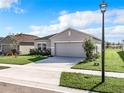 Charming one-story home featuring a well-manicured lawn, inviting front entrance, and attached two-car garage at 993 Calico Pointe Cir, Groveland, FL 34736