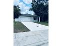 Single-story home featuring a concrete driveway, white exterior and an attached garage at 1015 25Th St, Orlando, FL 32805