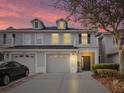 Charming townhouse featuring a two-car garage and a lovely sunset backdrop at 1218 Falling Star Ln, Orlando, FL 32828