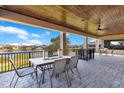 Covered patio with wood ceiling, stone floor, metal chairs, and a lake view at 13231 Woodford St, Orlando, FL 32832