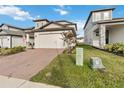 Charming two-story home featuring a brick driveway and a well-manicured front yard at 2242 Huntsman Ridge Rd, Clermont, FL 34715