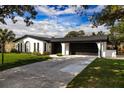 Attractive one-story home with modern updates and a spacious driveway, complemented by lush green surroundings at 2555 Sweetwater Trl, Maitland, FL 32751