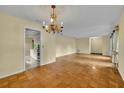 Open-concept living area features parquet floors, a chandelier and a clear view into the adjacent kitchen space at 2642 Tierra Cir, Winter Park, FL 32792