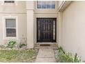 A close up of the home's dark colored front door, sidelights, and arched window at 2645 Coachman Dr, Deltona, FL 32738