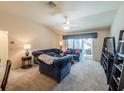 Bright living room with vaulted ceiling, comfortable seating, and sliding glass doors to the outdoor patio at 2936 Suber St, The Villages, FL 32163