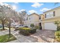 A well-maintained townhome with a one-car garage, attractive landscaping, and a brick-paved driveway in a desirable neighborhood at 3257 Villa Strada Way, Orlando, FL 32835