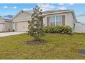 Landscaped front yard with a decorative tree and tan exterior of a single Gathering home at 337 Regency Ridge Dr, Davenport, FL 33837