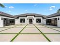 Eye-catching house with decorative driveway that features a modern design, black trim, and glass garage doors at 3845 S Stillwood Ln, Lake Mary, FL 32746