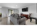 Comfortable living room with a large gray sofa and a sliding glass door for access to the backyard at 411 Ridges Dr, Dundee, FL 33838