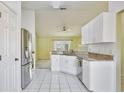 Bright kitchen featuring white cabinets, granite countertops, and stainless steel appliances overlooking the living area at 4702 Kati Lynn Dr, Apopka, FL 32712