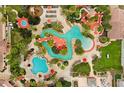 Stunning aerial view of a resort-style pool area featuring winding water features, lush landscaping, and plenty of lounge seating at 487 La Mirage St, Davenport, FL 33897