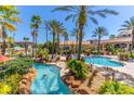 Inviting resort-style pool with a lazy river, lush palm trees, and comfortable lounge chairs for relaxation and enjoyment at 487 La Mirage St, Davenport, FL 33897