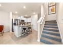 Modern kitchen featuring a breakfast bar, stainless steel appliances, and bright white cabinetry at 512 Preston Cove Dr, St Cloud, FL 34771