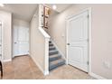 Hallway with staircase featuring carpeted steps, white trim, and neutral walls, with art hanging on the walls at 5669 Brosnan Rd, St Cloud, FL 34771