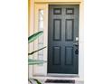 A stylish front door is equipped with a keypad entry and adjacent glass pane for added light at 6855 Sperone St, Orlando, FL 32819