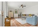 Bright living room featuring terracotta tile flooring, neutral furniture, and a ceiling fan, creating a comfortable atmosphere at 90 Cedar Dunes Dr, New Smyrna Beach, FL 32169