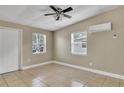 Cozy bedroom with neutral walls, tile floors, and a ceiling fan for comfort at 906 Ferndell Rd, Orlando, FL 32808