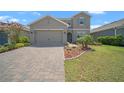 Charming two-story home featuring a two-car garage, manicured lawn, and decorative landscaping at 9180 Carmela Ave, Davenport, FL 33897