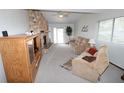 Cozy living room with a stone fireplace, plush sofas, and bright natural light at 1104 Southampton Dr # 3, Port Orange, FL 32129