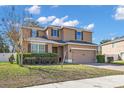 Inviting two-story home featuring manicured landscaping, a brick paver driveway, and an attached two-car garage at 1465 Osprey Ridge Dr, Eustis, FL 32736