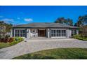 Inviting front exterior with brick driveway, two rocking chairs, and a lush landscaped front yard with many plants at 1591 Chippewa Trl, Maitland, FL 32751