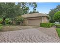 Side view of the house showing a garage with a driveway paved with pavers at 1921 Redwood Grove, Lake Mary, FL 32746