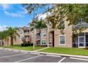 Tan condo building with stairwells, screened patios, palm trees and parking at 2305 Butterfly Palm # 102, Kissimmee, FL 34747