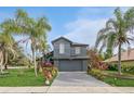 Charming two-story home boasts neat landscaping, a long driveway, and lovely palm trees in a desirable neighborhood at 2405 Abalone Blvd, Orlando, FL 32833