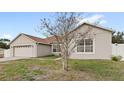 Exterior shot of single-story home with a driveway and attached garage at 2537 Rock Pl, Poinciana, FL 34759