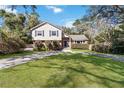 Inviting two-story home with a manicured lawn, mature trees, and a classic brick and siding exterior at 259 Westchester Dr, Deland, FL 32724