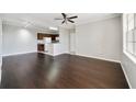 Living room with hardwood floors, neutral walls, a ceiling fan, and a partial view of the kitchen area at 2624 Robert Trent Jones Dr # 634, Orlando, FL 32835