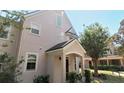 Front exterior view of a well-kept townhome featuring a quaint porch and tidy landscaping at 3364 Westchester Square Blvd # 104, Orlando, FL 32835