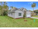 A charming gray home has a paved drive, manicured lawn and landscaping at 340 Bahia Cir, Longwood, FL 32750