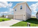 Tan two-story home with a two-car garage, a well-manicured lawn, and a concrete driveway at 3507 Salvia Ct, Tavares, FL 32778