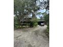 Scenic view of the log cabin home with long driveway, mature trees, and landscaping at 40201 Jericho Trl, Eustis, FL 32736