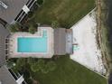 Aerial view of a pool with a clubhouse, sandy beach, and lush landscaping near the waterfront at 4117 Fairview Vista Pt # 105, Orlando, FL 32804