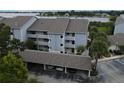 Exterior view of a light-blue condo building with private patios and covered parking, surrounded by lush landscaping at 4117 Fairview Vista Pt # 105, Orlando, FL 32804