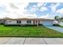 Charming single-story home with a manicured lawn, tidy landscaping, and a convenient two-car garage at 4416 Flagg St, Orlando, FL 32812