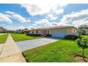 Charming single-story home with a manicured lawn, tidy landscaping, and a convenient two-car garage at 4416 Flagg St, Orlando, FL 32812