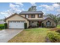 Charming two-story home with a well-manicured lawn, mature trees, and a two-car garage at 445 Autumn Oaks Pl, Lake Mary, FL 32746