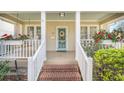 Close-up of front porch with brick steps, white railings, flower boxes, and a pale blue front door at 616 Sheridan Blvd, Orlando, FL 32804