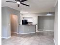 Open floor plan featuring tile floors, crown molding, and an open kitchen counter at 6408 Raleigh St # 2402, Orlando, FL 32835