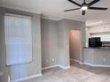 Bright living room features tile floors, modern ceiling fan, neutral paint, and natural light at 6408 Raleigh St # 2402, Orlando, FL 32835